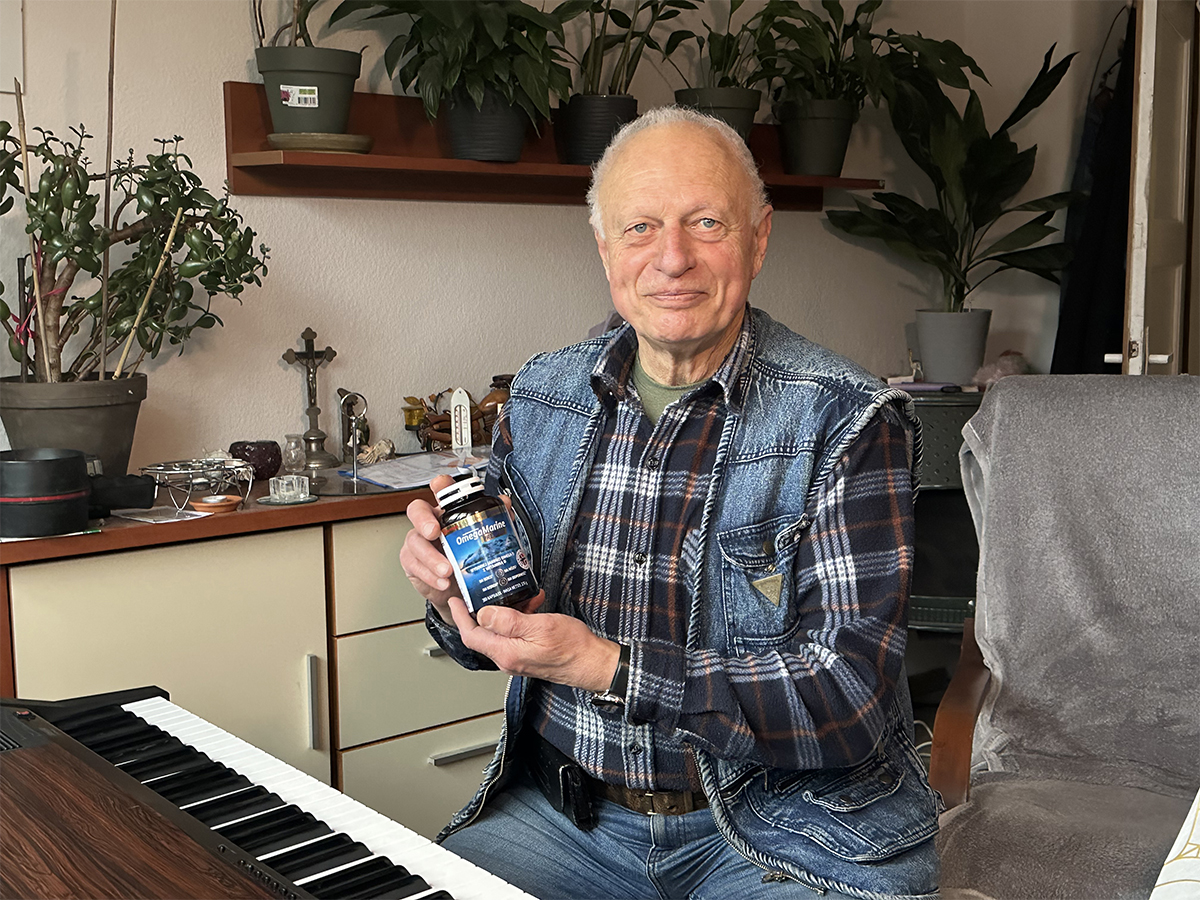 Dobry wzrok w wieku 78 lat Pan Zdzisław z Olsztyna siedzi przed pianinem i trzyma butelkę Omega Marine.